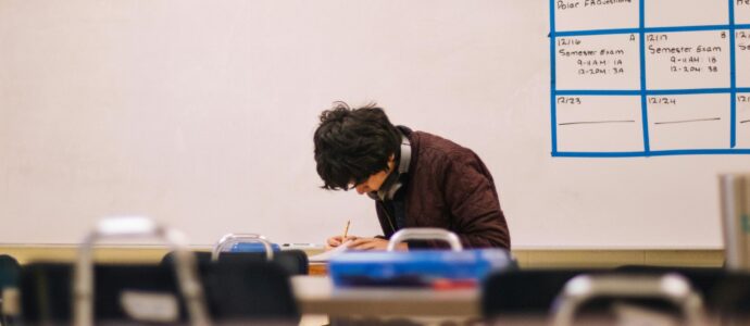 Student writing in a classroom