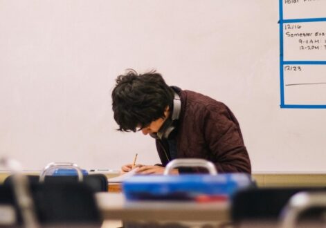 Student writing in a classroom